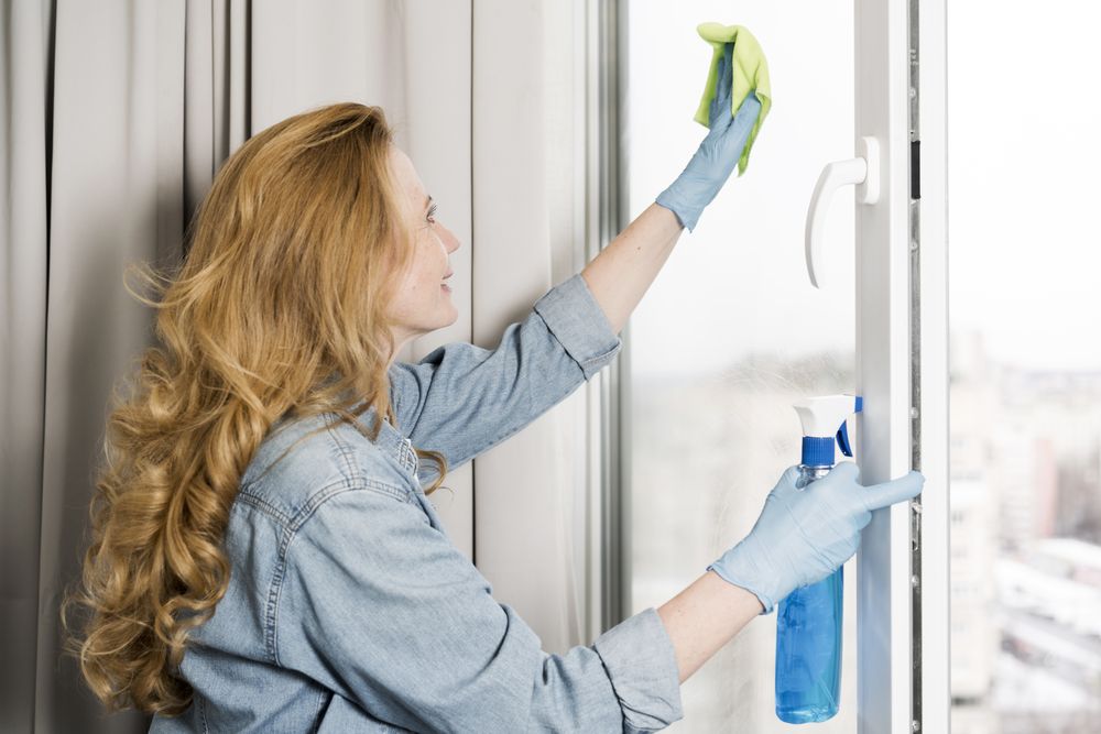 side-view-woman-wiping-window